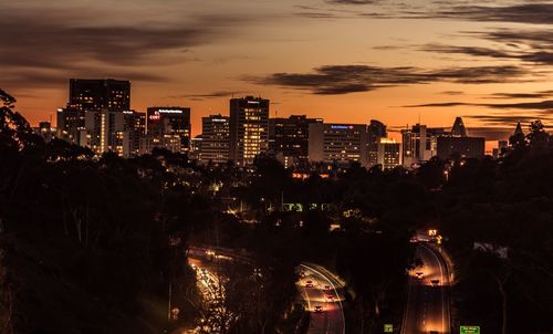 Illuminated cityscape against sky at night