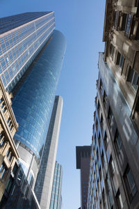 Low angle view of modern buildings against clear blue sky