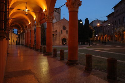 Illuminated street amidst buildings at night