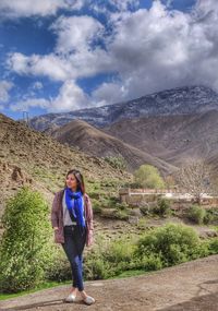 Woman standing on mountain against sky