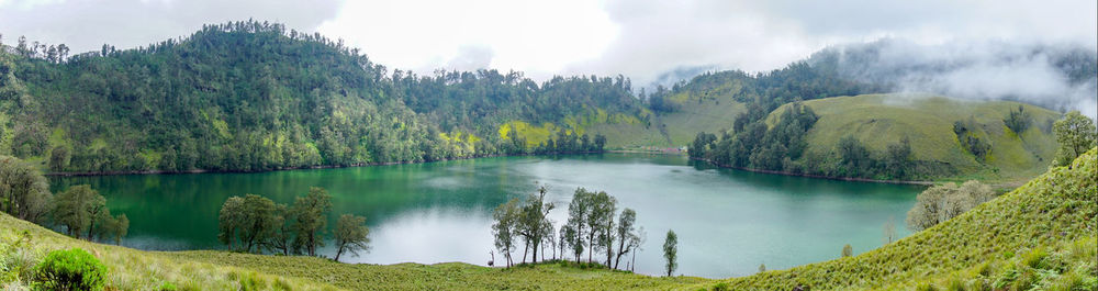 Panoramic view of lake and trees against sky