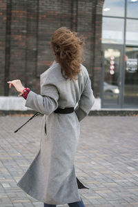 Rear view of woman standing on footpath