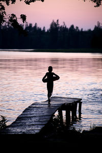 Silhouette of woman in lake at sunset