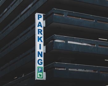 Low angle view of road sign against wall