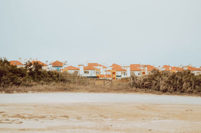 Houses on field against clear sky