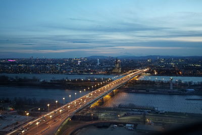 High angle view of illuminated city against sky at dusk