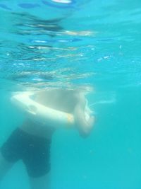 Midsection of man swimming underwater