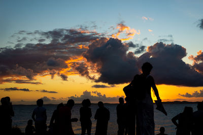 Silhouette people standing against sky during sunset