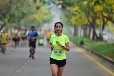 Young woman running on road