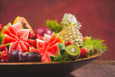 Close-up of fruits on table against red background