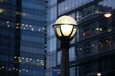 Low angle view of illuminated lamp in city at night