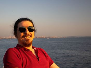 Portrait of smiling mid adult man against sea against sky