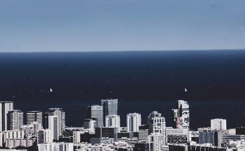 Aerial view of city against blue sky