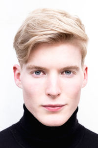 Close-up portrait of handsome young man against white background