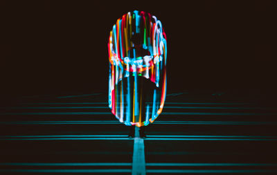 Close-up of illuminated lighting equipment against black background