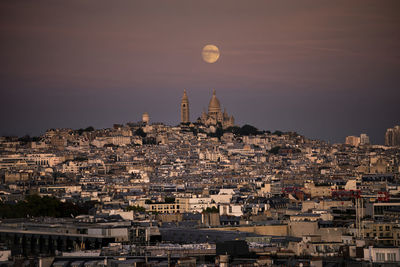 The moon rises over montmatre, paris 