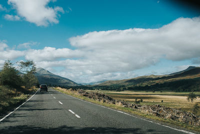 Empty road along landscape against sky