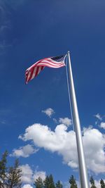 Low angle view of flag against blue sky