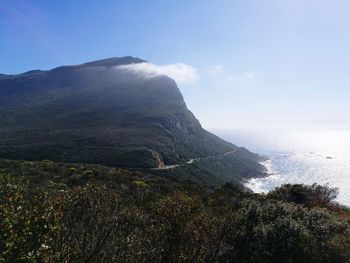 Scenic view of sea and mountains against sky