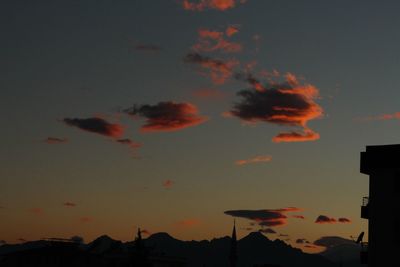 Silhouette of mountain against cloudy sky at sunset