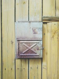 Rusty mailbox on wooden door