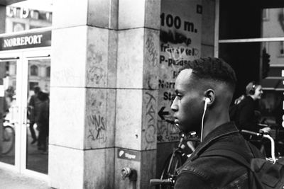 Side view of young man looking away in city