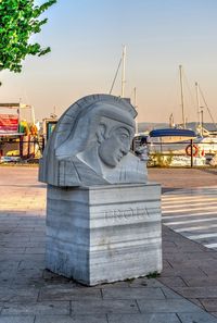 Statue of harbor against sky in city