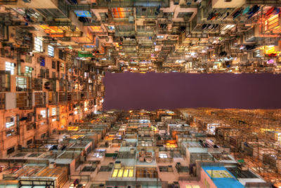 Low angle view of illuminated buildings against sky in city