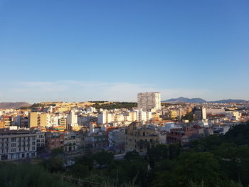 High angle view of buildings against clear blue sky