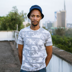 Portrait of young man standing against trees