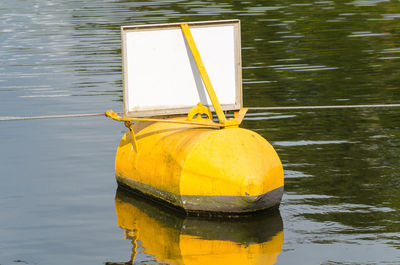 Close-up of yellow tied to floating on water