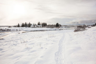 Scenic view of snow covered field against sky