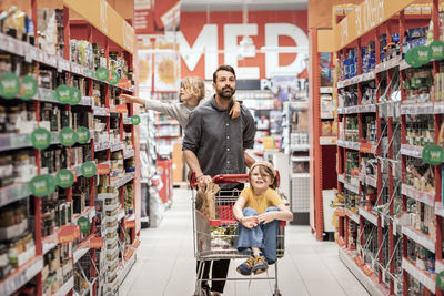 Father with daughters doing shopping in supermarket