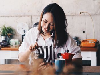 Young woman sitting on table at home