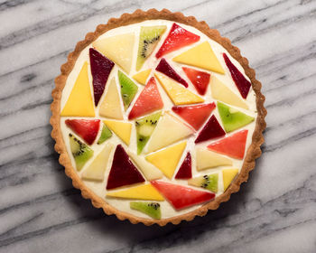 Abstract fruit tart with mango, kiwi, plum, and peach