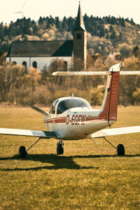 Airplane flying over land against sky