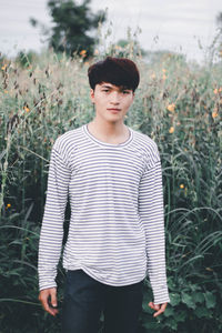 Portrait of young man standing on field