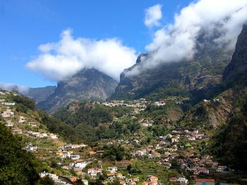 Scenic view of townscape and mountains against sky