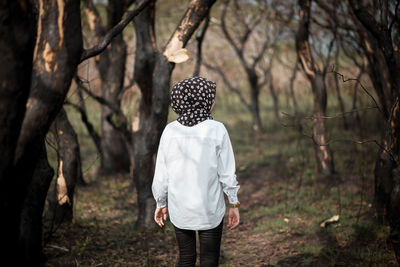 Rear view of woman standing on field