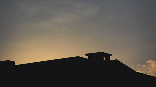 Low angle view of silhouette building against sky during sunset