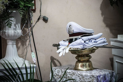 Close-up of statue on table against wall