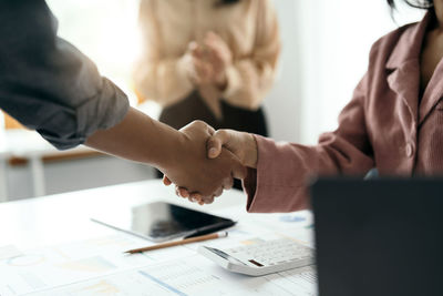 Midsection of business colleagues shaking hands