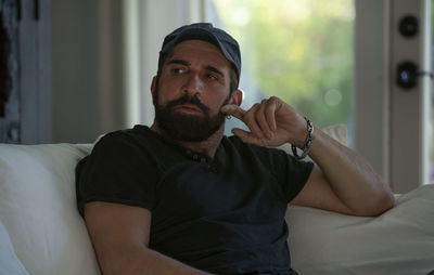 Young man sitting on bed at home