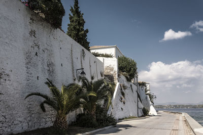 Walkway by building against sky