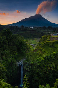 Scenic view of waterfall against sky during sunrise
