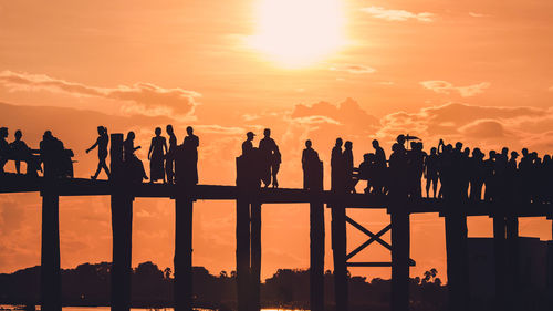 Silhouette people looking at sunset