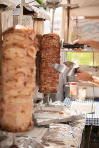 Cropped image of hand preparing meat in commercial kitchen