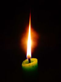 Close-up of illuminated candle against black background