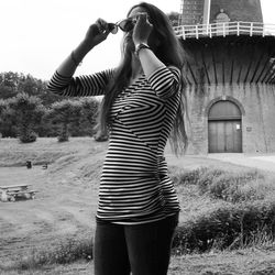 Full length of young woman standing on grass