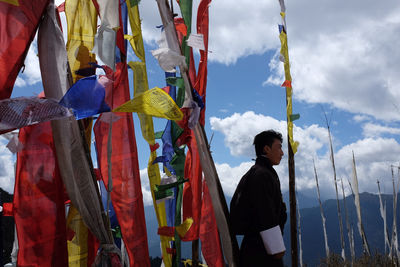 Man standing with multi colored umbrella against sky